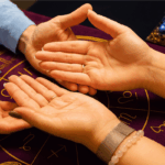 Séance de chiromancie avec deux mains ouvertes sur un tapis astrologique, illustrant la voyance par la main et la lecture des lignes