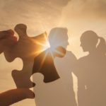 Jeune couple se tenant la main en courant sur la plage au coucher du soleil, symbolisant les etapes d une relation amoureuse epanouie