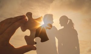 Jeune couple se tenant la main en courant sur la plage au coucher du soleil, symbolisant les etapes d une relation amoureuse epanouie